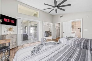 A bedroom with a bed, a desk, a chair, a TV, and a ceiling fan. - Lakeland 3BR | Pool, AC Gameroom & HUGE Yard (Lakeland)