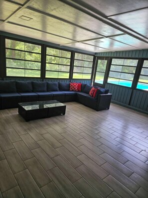 A covered outdoor seating area with a sectional sofa and a glass coffee table. - Private Pool • Sleeps 16 • Huge Yard • AC GameRoom (Lakeland)