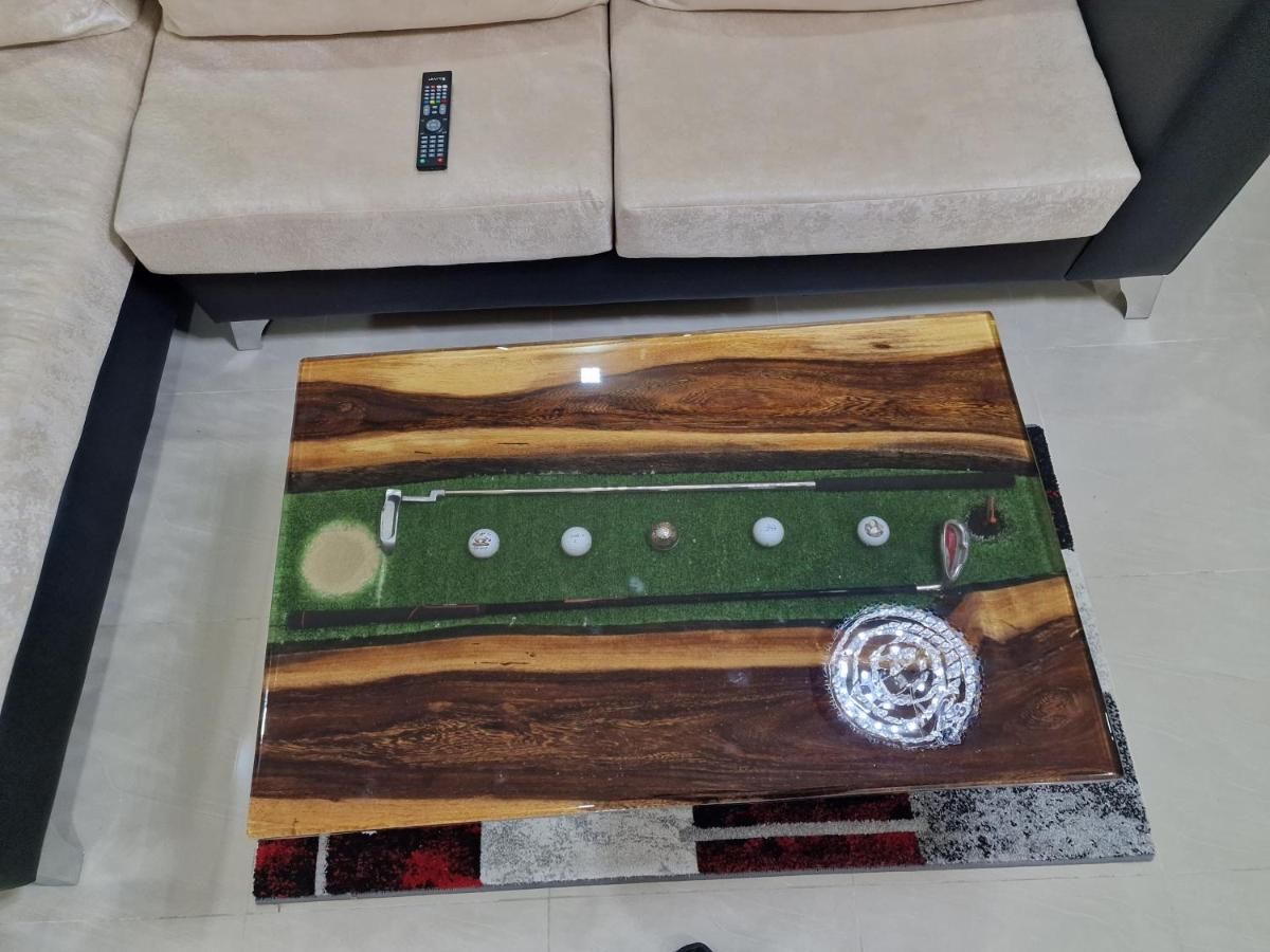 Ein Billardtisch mit Holzstruktur, grüner Spielvliesbahn und Spielstöcken.