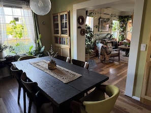 Uma área de refeições com uma mesa de madeira, cadeiras e um vaso de flores.