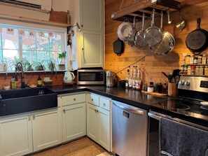 A modern kitchen with white cabinets, a black countertop, and stainless steel appliances. - Comfortable and quirky updated 3-bedroom bungalow in peaceful Monroe (Monroe)
