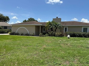 A residential house with a well-maintained lawn, a palm tree, and a mailbox. - 4 Bedroom Cul-de-Sac Pool Home w/ Gameroom (Lakeland)