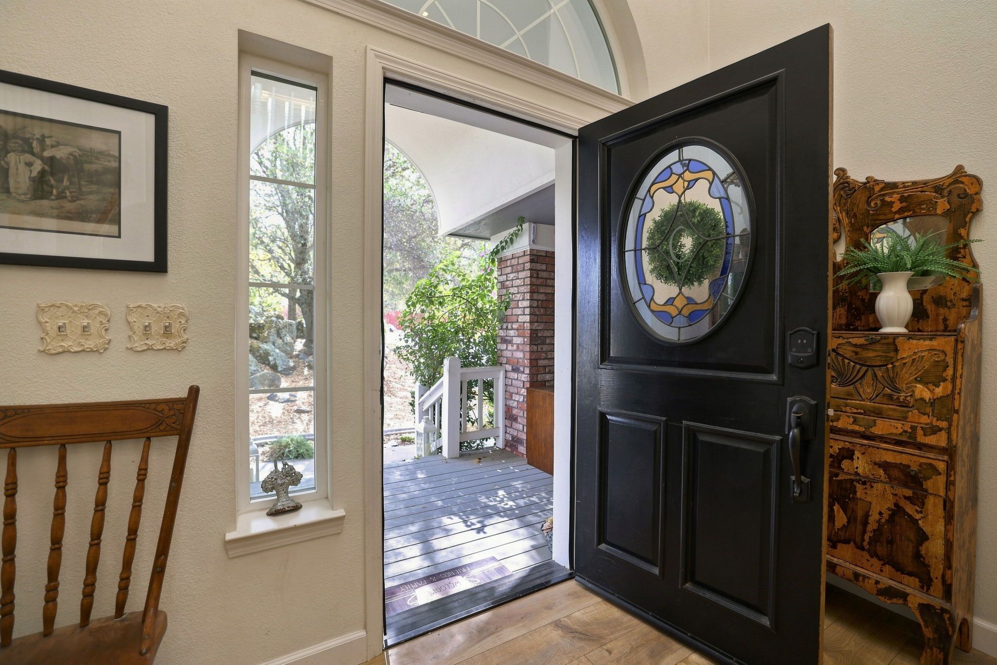 A doorway with a decorative glass panel, a wooden bench, and a rustic cabinet.