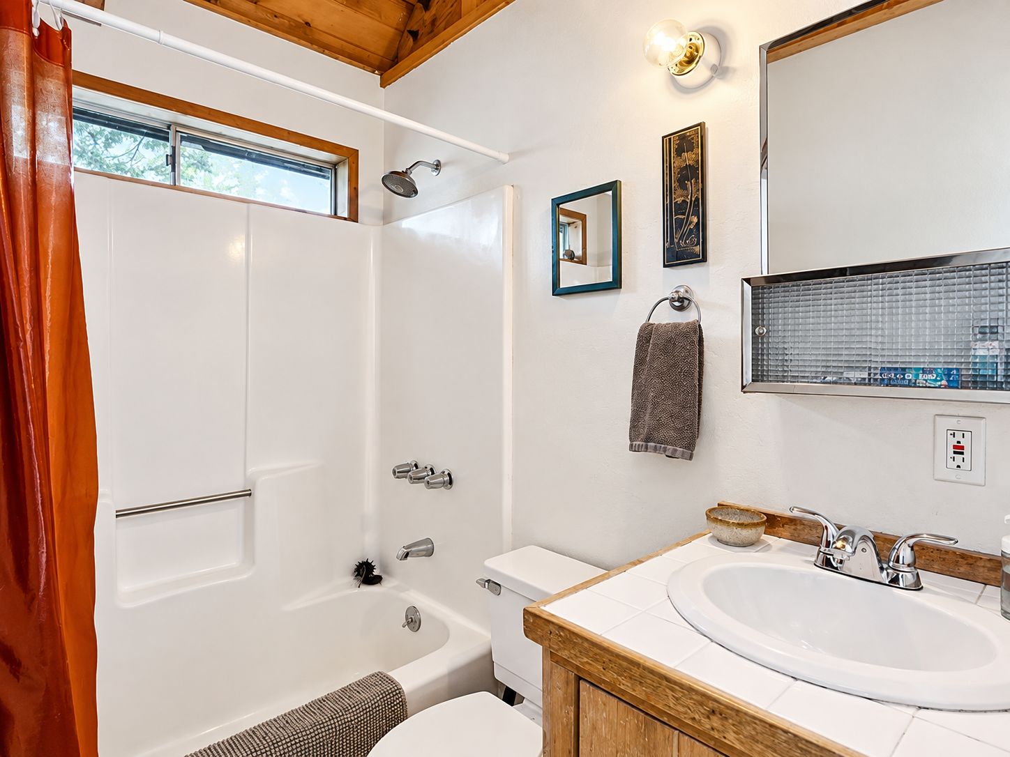 A bathroom with a bathtub, toilet, sink, and a shower.