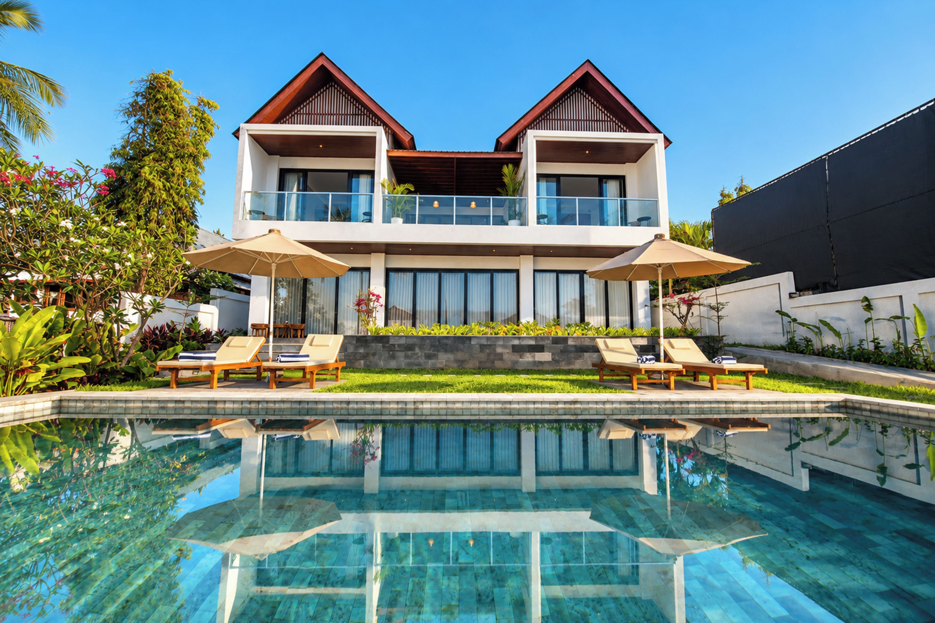 A two-story house with a swimming pool in front.