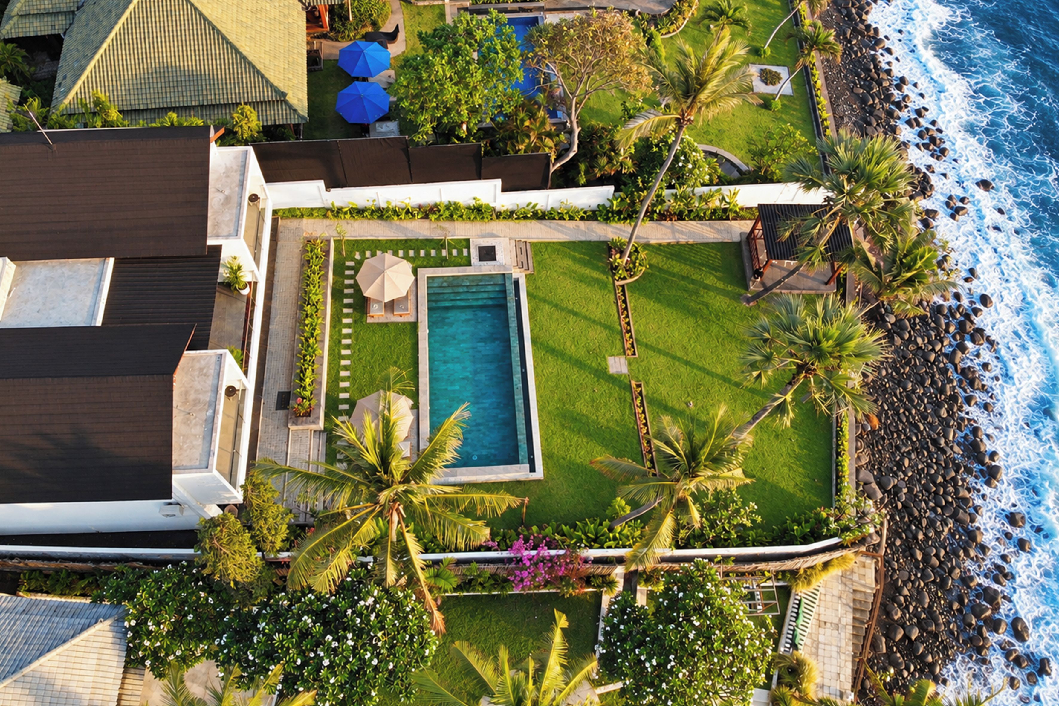 A residential property with a swimming pool, a patio area, and a view of the ocean.