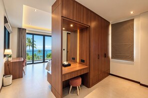 A modern hotel room with a wooden desk, a view of the ocean, and a large window. - 3-Bedroom Beach Front Villa with Ocean View in Tulamben Karangasem Bali (Karangasem)