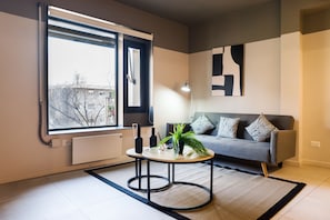 A modern living room with a sofa, a coffee table, and a large window. - Featured Design · 1 bedroom and 2 bathrooms · sleeps 4 (H20) (Providencia)