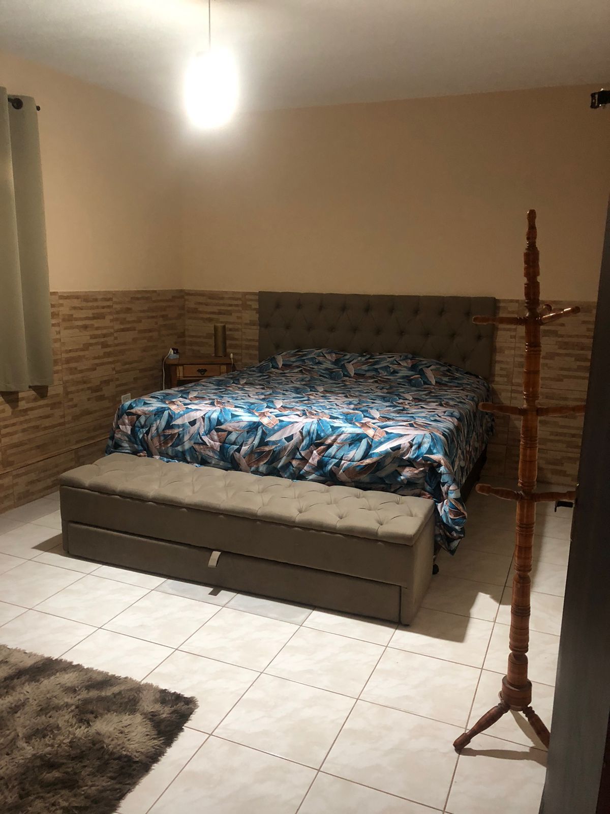 A bedroom with a bed, bedside table, and a floor lamp.