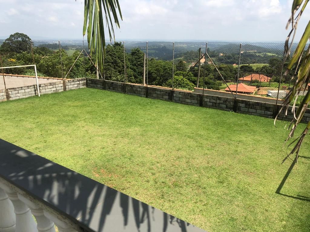 A grassy backyard with a view of the landscape.