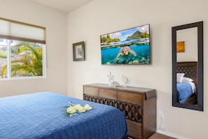 A bedroom with a bed, a dresser, a framed picture, and a mirror. - Pool & Ocean View Villa: 3BD | Sunset Kona Side (Kailua-Kona)