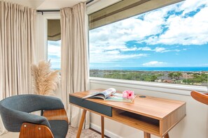 A room with a wooden desk, a chair, and a view of the ocean. - Upgraded 3 bed w Ocean View, Pool, Hot tub, 2 King (Waikoloa Village)
