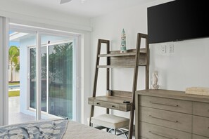 A bedroom with a bed, a wooden desk, a chair, a dresser, and a TV mounted on the wall. -  Naples Beach 3BR Home with Amazing Pool,Hot Tub,garage,2 MI to the Beach (Naples)