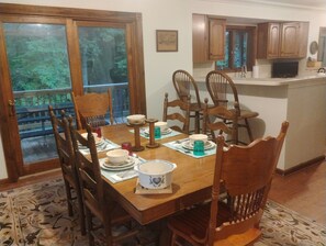 A dining room with a wooden table set for four, surrounded by chairs. - 4 BR Mountain Retreat in Stunning Hardwood Forest: Big Views & Friendly Goats (Blairsville)