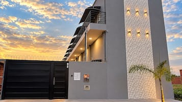 Een modern gebouw met een garagepoort, een trap en een gestructureerde muur.