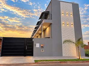 Un edificio moderno con puerta de garaje, una escalera y pared con textura.