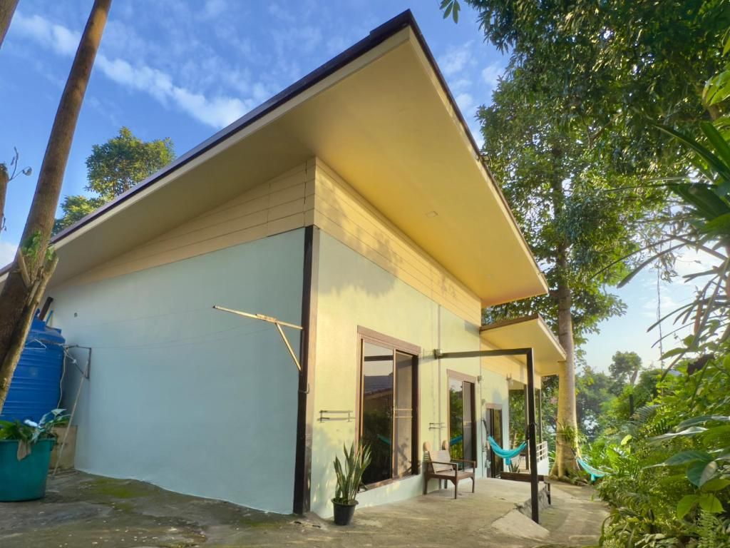 A single-story building with a flat roof, a covered porch, and a hammock.