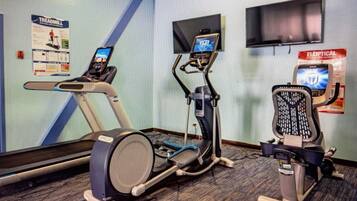 A fitness room with treadmills, an elliptical, and a stationary bike.