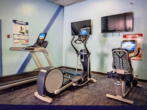 Kuntosali, jossa on juoksumattoja, kuntopyörä ja crosstrainer.