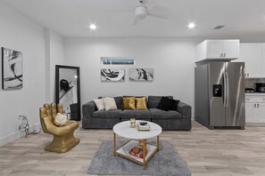 Ein modernes Wohnzimmer mit einem grauen Sofa, einem runden Couchtisch und einem einzigartigen goldfarbenen Sessel.