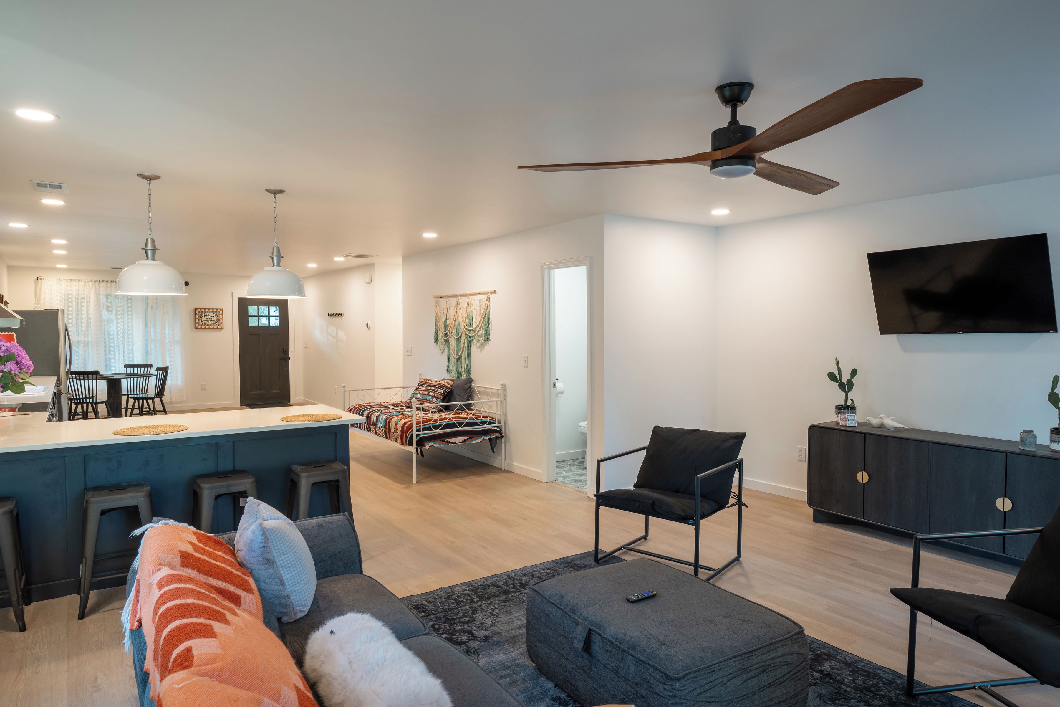 A modern living space with a kitchen, dining area, and seating area.