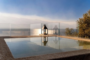 A clear glass infinity pool with a view of a body of water and mountains in the distance. - Liuzhao Mountain View Holiday Hotel (Dali)