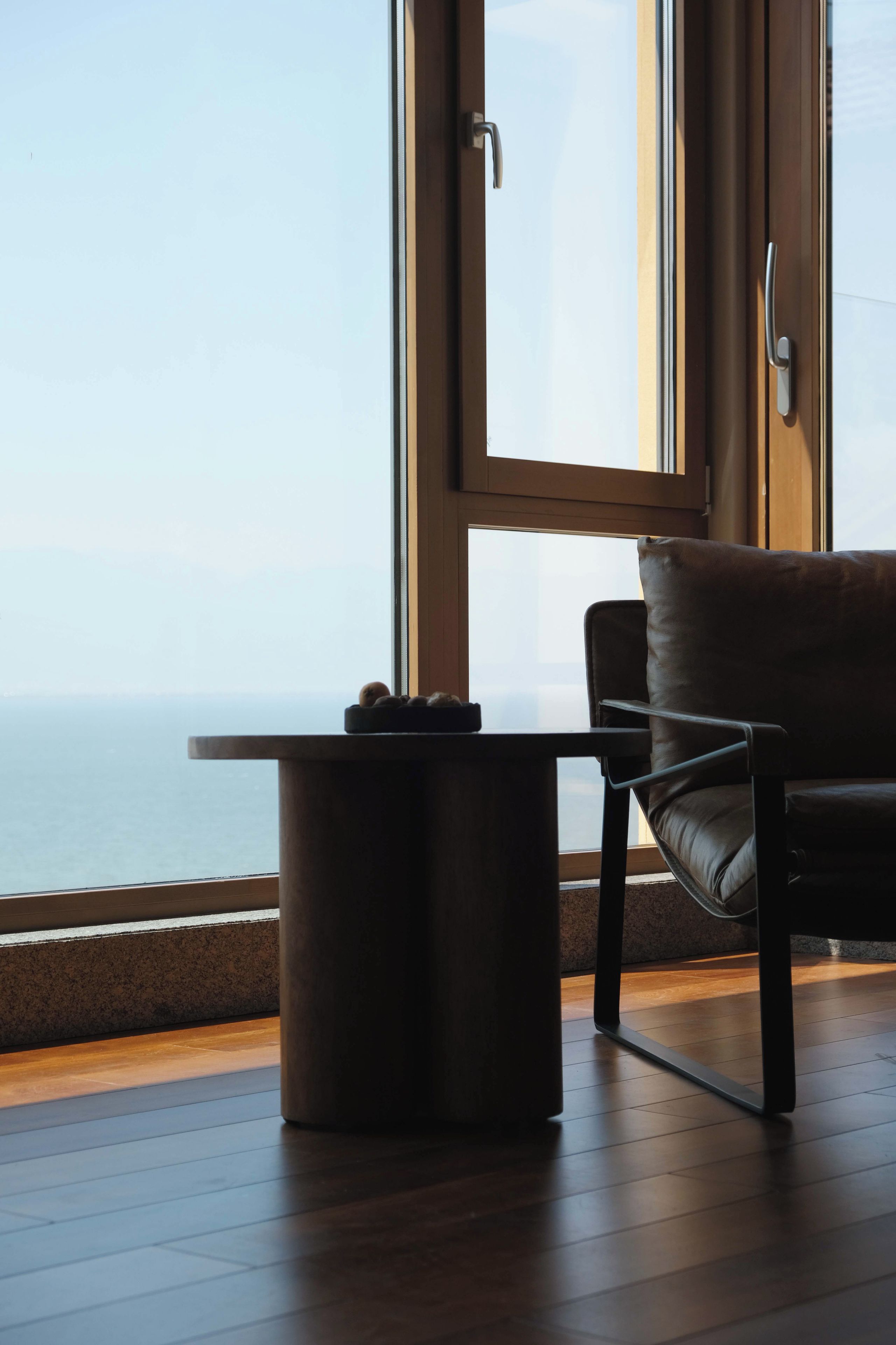 Une pièce avec vue sur la mer, une chaise, une petite table et une porte.