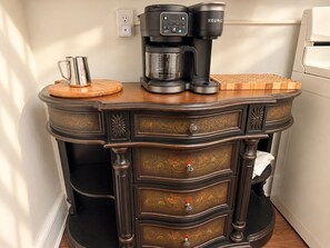 A kitchen counter with a coffee maker, a mug, and a cutting board. - Equestrian 2BR near Longwood Gardens & Kennett Sq (West Grove)