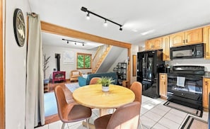Eine moderne Küche mit Holzausstattung, einem schwarzen Kühlschrank und einem eingebauten Backofen.