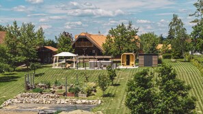 Un immobile residenziale con patio coperto, sauna e prato curato.