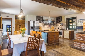 Una cucina con mobili in legno, un tavolo da pranzo con sedie e un'isola centrale.
