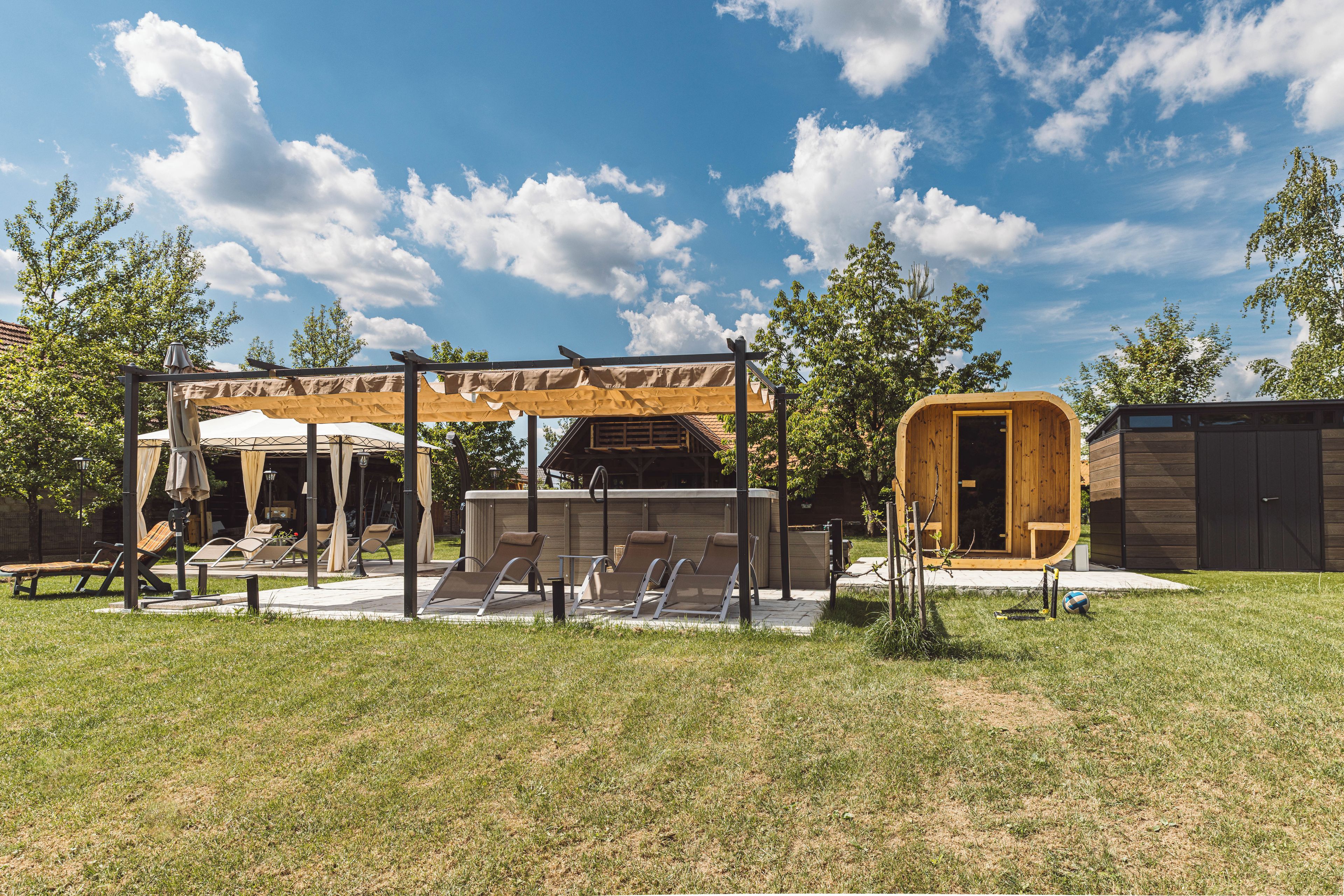 Ein überdachter Außenbereich mit Liegestühlen und einer Pergola.
