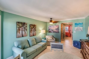 A living room with a sofa, a chair, a table, and artwork on the walls. - Stay at Bluewater with Balcony,Beach & Pool Access (Myrtle Beach)