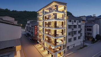 A multi-story hotel with a modern design, featuring balconies and large windows.