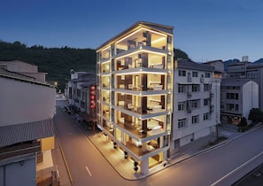 A multi-story hotel with a modern design, featuring balconies and large windows. - 1982.XI  (Zhangjiajie)