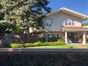 A two-story house with a front porch, a large tree, and a well-maintained lawn. - Spacious 4-bedroom house on a quiet wooded cul de sac (Boulder)