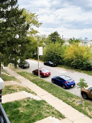 Una calle residencial con coches aparcados y una acera.