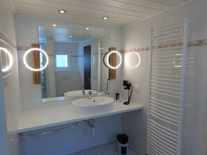 A modern bathroom with a large mirror, two ring lights, a sink, and a toilet. - Eden 4 OG Brunegghorn, (Grächen), by Interhome (Grächen)