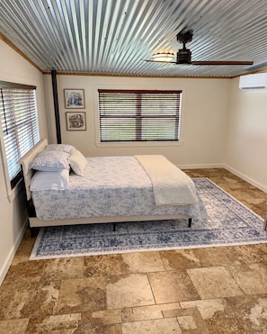 A bedroom with a bed, a window with blinds, a ceiling fan, and a rug. - Lovely 3-bedroom house just minutes from Downtown Graham (Graham)