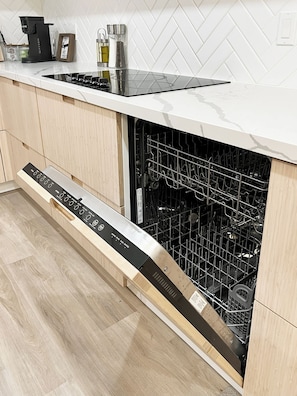 A modern kitchen with a built-in dishwasher, a coffee maker, and a spice rack. - Westmount Retreat | 5 Bedrooms, 2 Baths & Free Parking (Hamilton)