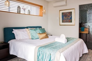 A neatly made bed with a teal headboard, white bedding, and decorative pillows. - Fragrant Harbour with stunning ocean views (Gnarabup)