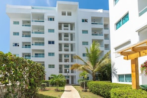 Un hôtel à plusieurs étages doté d’une cour intérieure, de balcons et d’un jardin bien entretenu.