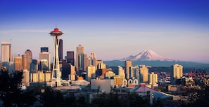 A cityscape with a prominent tower and a mountain in the background. - Tacoma Dome (Lakewood)