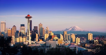 A cityscape with a prominent tower and a mountain in the background.