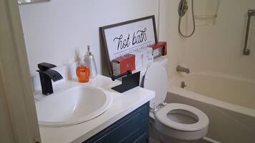 A bathroom with a white sink, a toilet, and a bathtub.