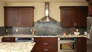 Kitchen with a professional-style range and stone counters - Riverwalk Retreat | Gather • Relax • Explore (Saugatuck)