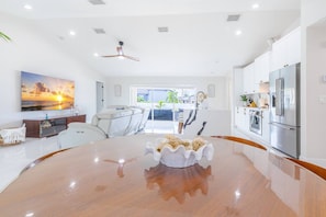 A modern kitchen with a large island, white cabinetry, and stainless steel appliances.