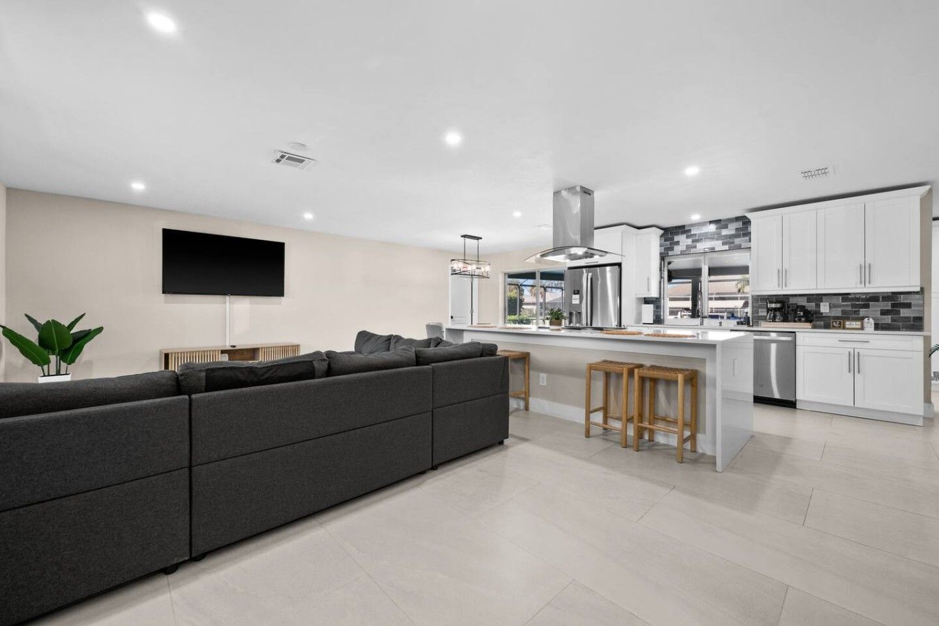 A modern kitchen with white cabinets, stainless steel appliances, and a central island.