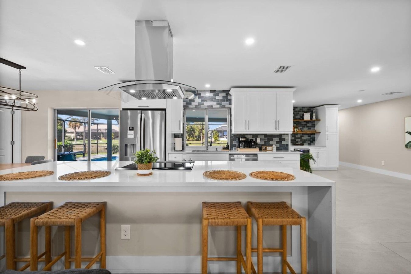 A modern kitchen with a central island, stainless steel appliances, and a view to the outdoors.