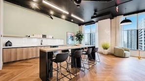 Eine moderne Küche mit Bar, großen Fenstern und Blick auf die Stadt.